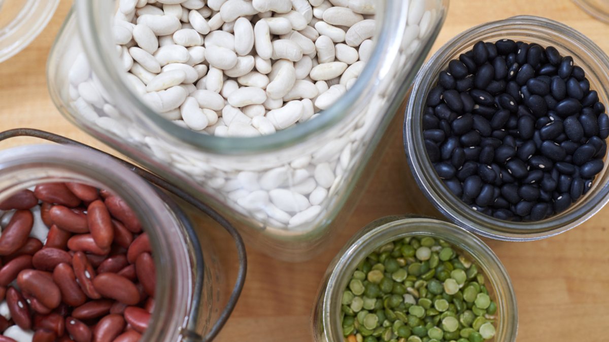 Glass jars of dried beans, lentils and split peas — store-cupboard staples